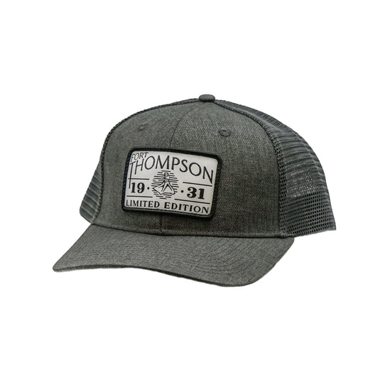 Fort Thompson White Rectangle Patch Trucker Style Hat in the color Charcoal with a rectangle patch that says 