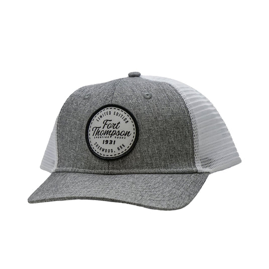Front view of the Fort Thompson White Circle Patch Trucker Style Hat showing a white patch that says "Limited Edition Fort Thompson Sporting Goods 1931 Sherwood, Ark." in black lettering on the center of the hat. 